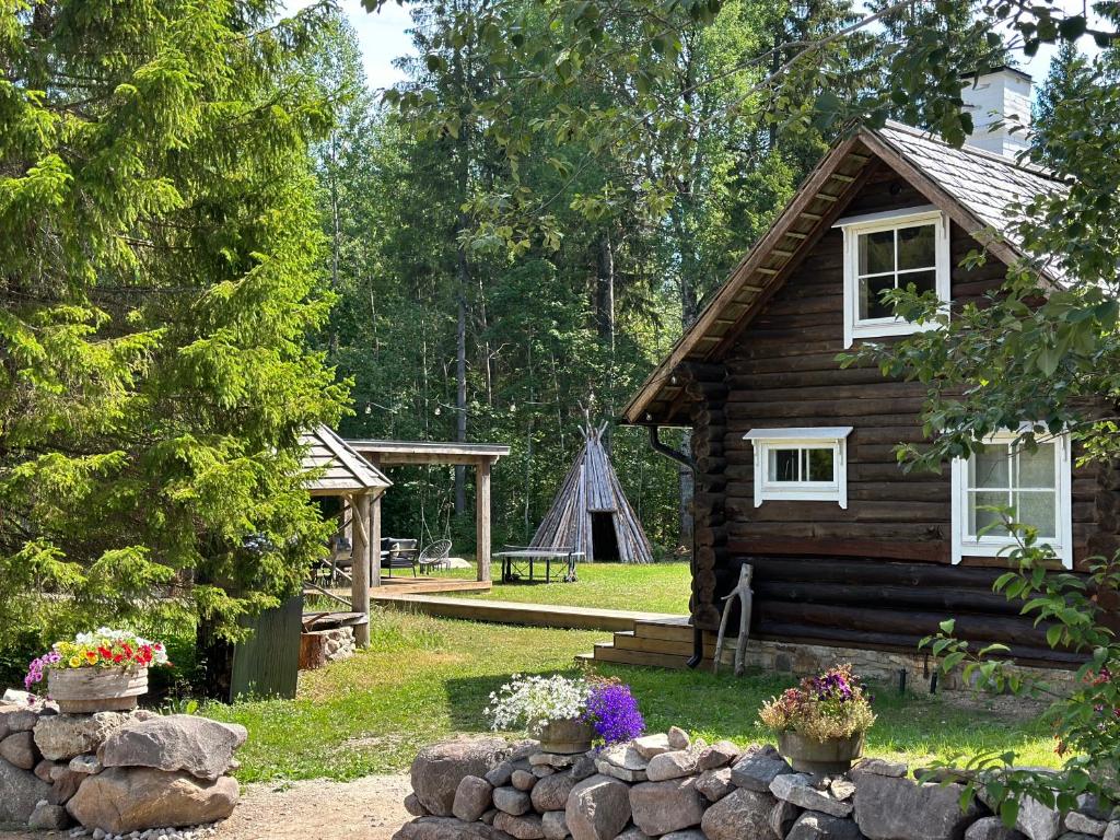 a log cabin with a garden and a playground at Panga Sauna Hut in Lähtru