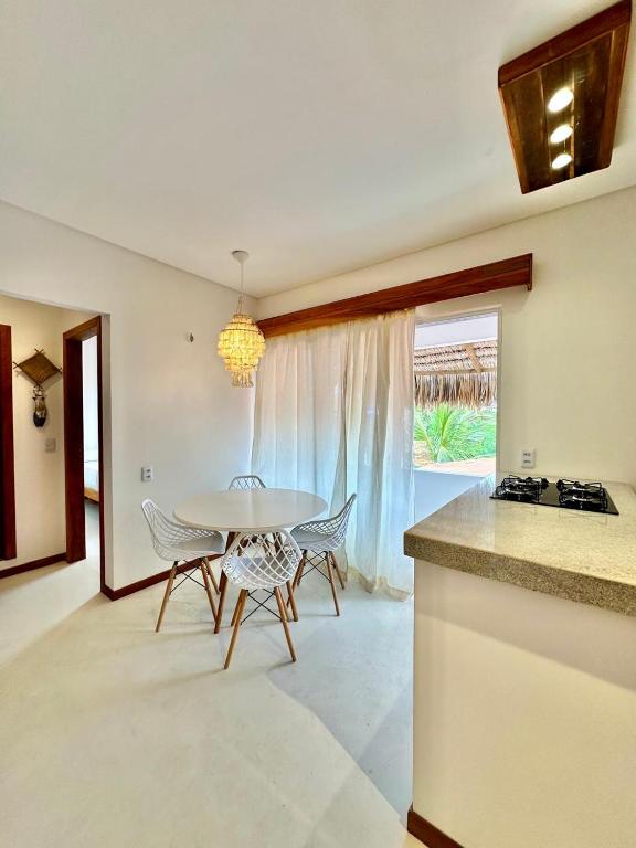 a kitchen and dining room with a table and chairs at Manay Preá, apartamento 2 quartos na melhor localização do Preá in Cruz