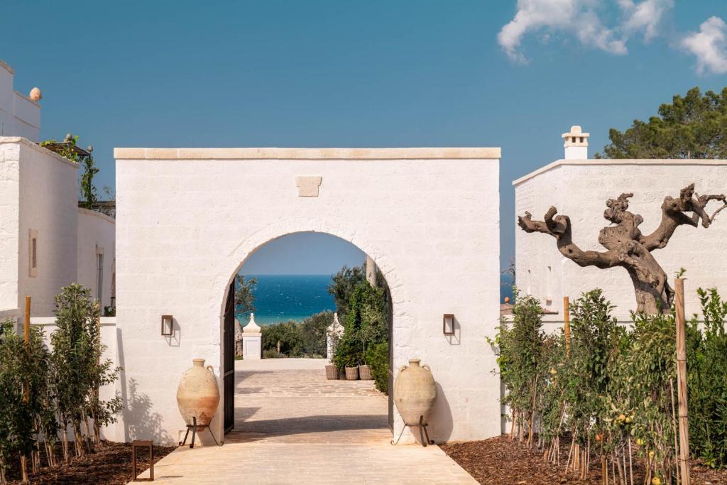 an entrance to a white building with an archway at Masseria Auraterrae in Polignano a Mare