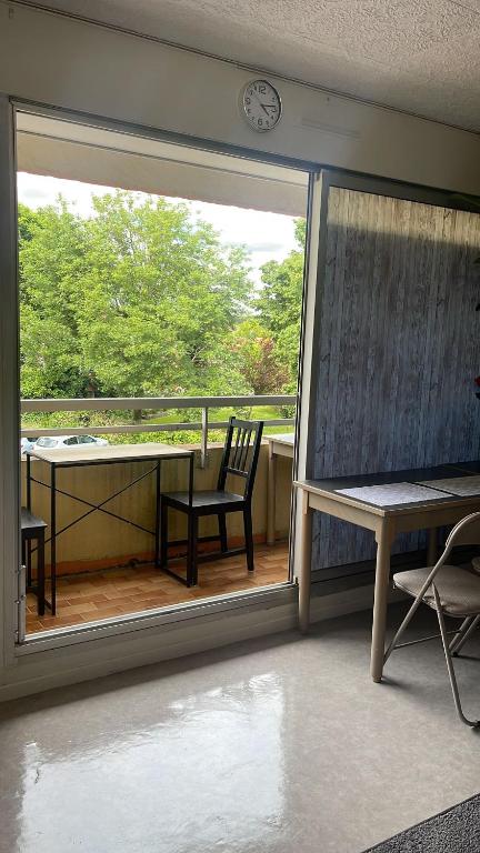 a view of a balcony with a table and a clock at Studio avec balcon proche des thermes in Saint-Paul-lès-Dax