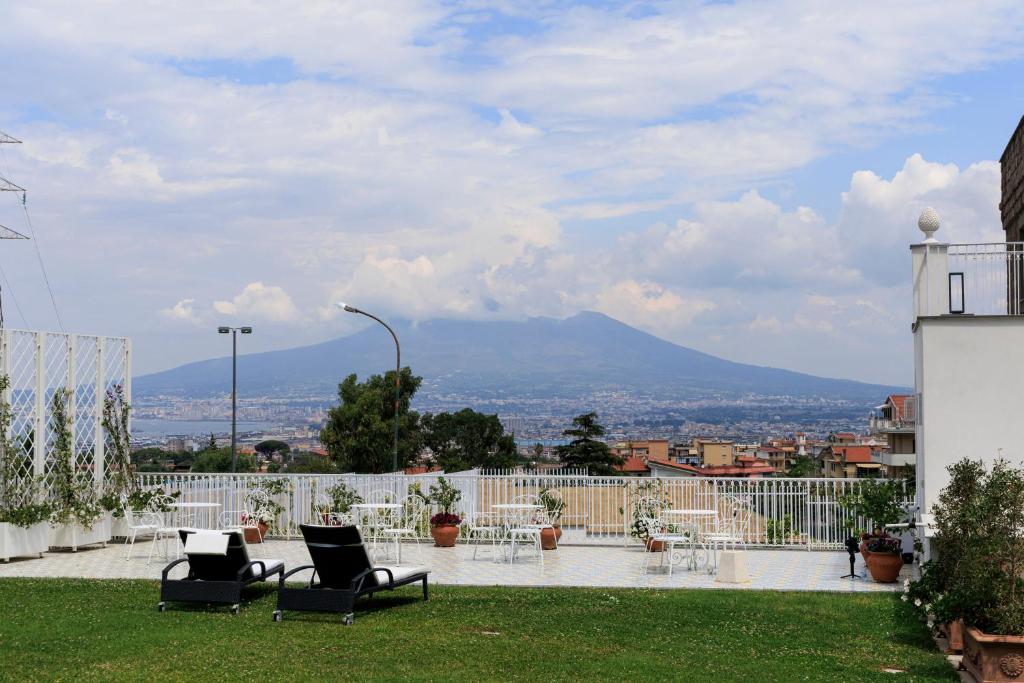 a patio with chairs and a view of a mountain at Villa Pia Suites in Castellammare di Stabia
