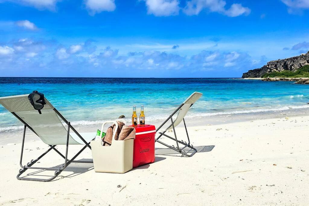 a couple of chairs and a cooler on a beach at NEW! Right at the Beach! Curazure Beach Condo, Jan Thiel in Willemstad
