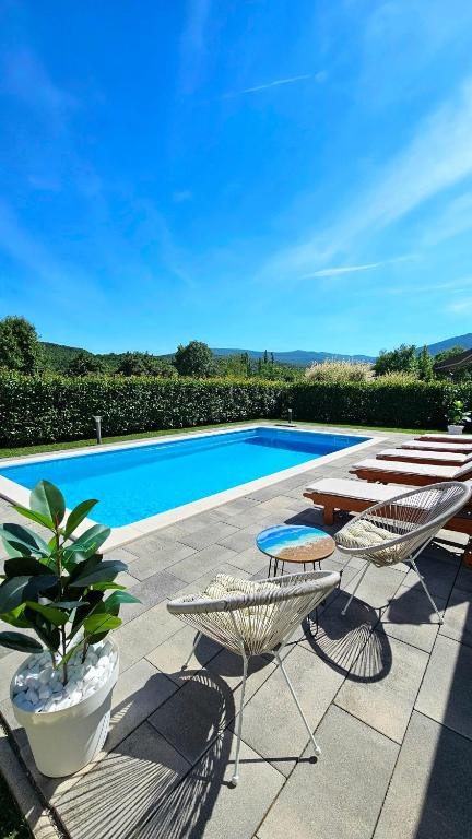 a swimming pool with a table and chairs next to a pool at Villa Fila in Sinj