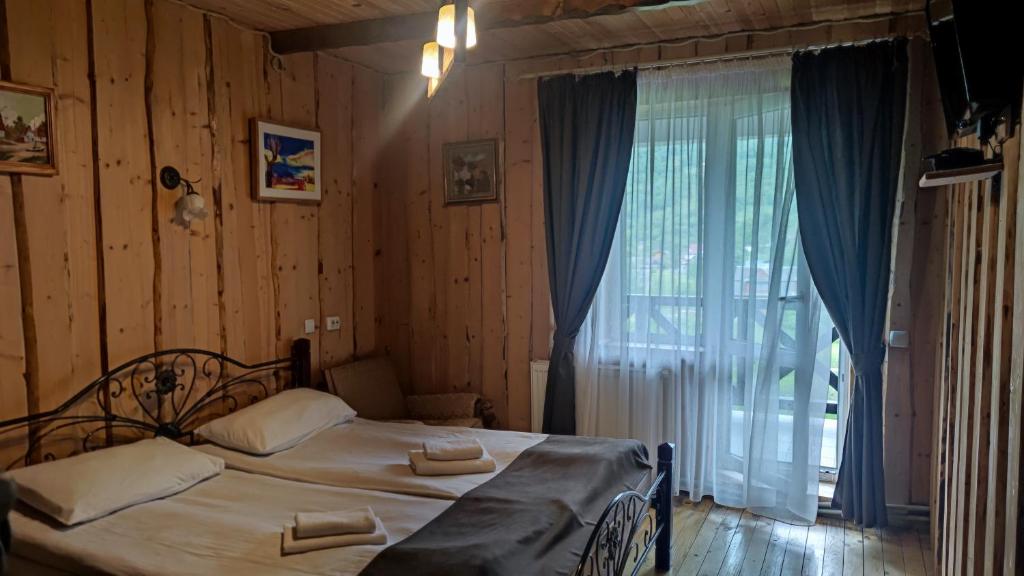 a bedroom with a bed and a large window at Gutsulska rodzynka in Yaremche