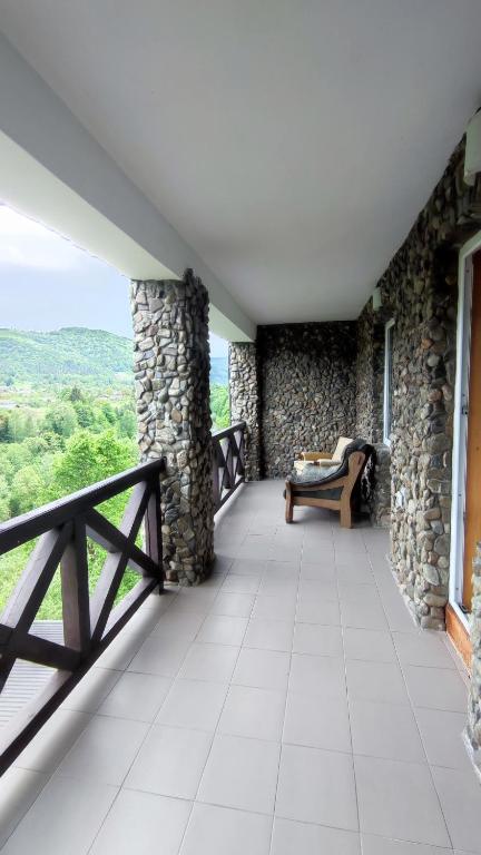 a balcony of a house with a bench and a fence at Gutsulska rodzynka in Yaremche