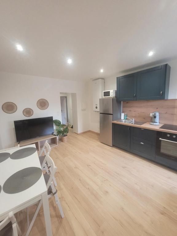 a large kitchen with a table and a counter top at Le Coquillage in Istres