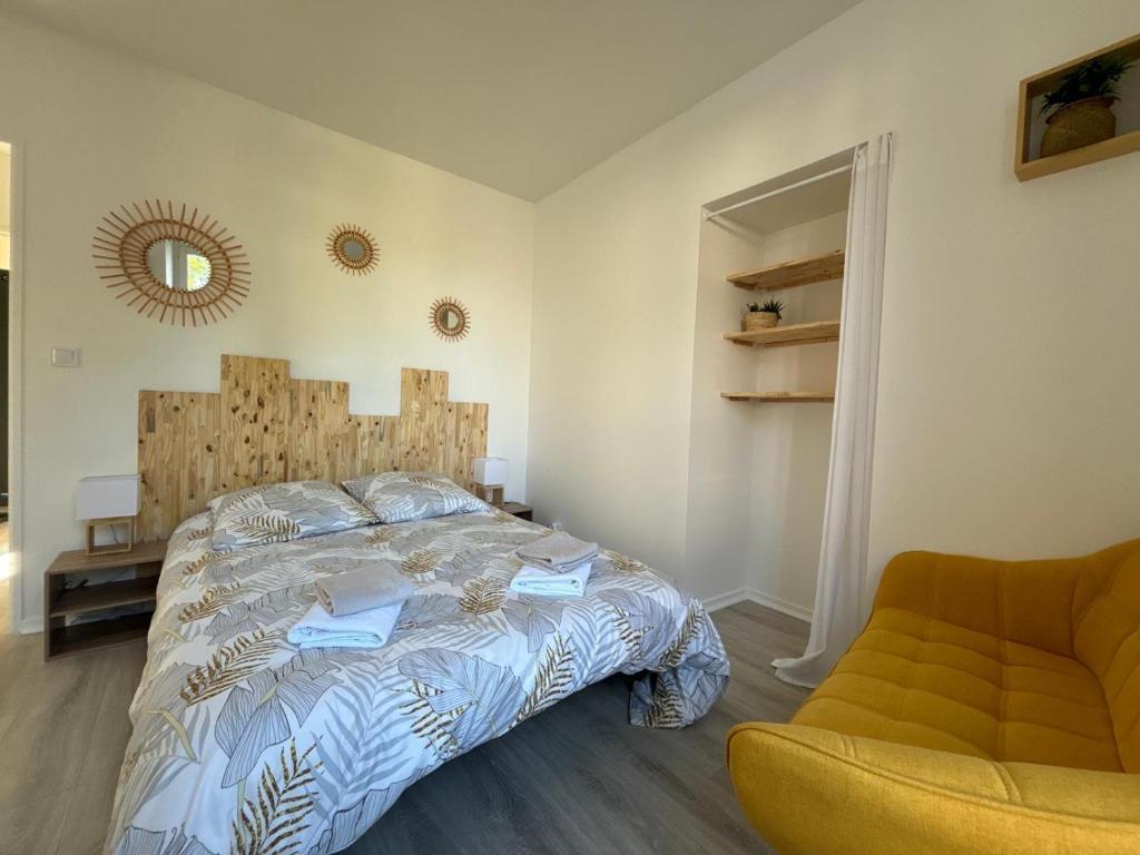 una camera da letto con un letto, una sedia e uno specchio di Ma Belle Conciergerie - COSY 2pièces centre Historique Milly-La-Foret a Milly-la-Forêt