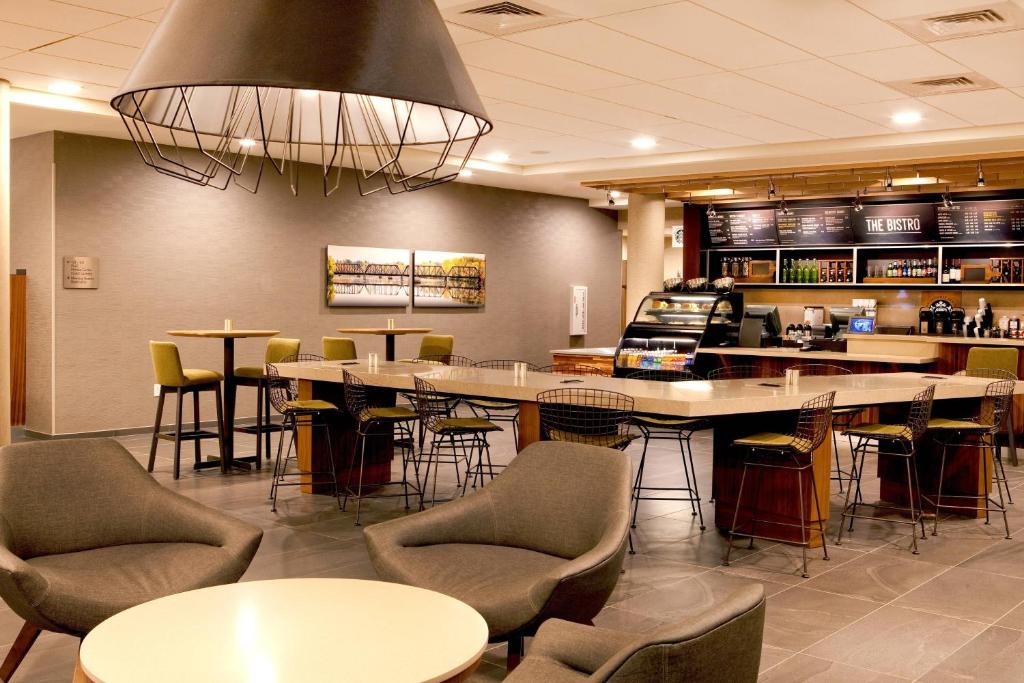 a restaurant with tables and chairs and a bar at Courtyard by Marriott Yonkers Westchester County in Yonkers