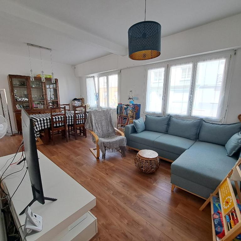 un salon avec un canapé bleu et une table dans l'établissement Maison de ville front de mer, à Saint-Nazaire