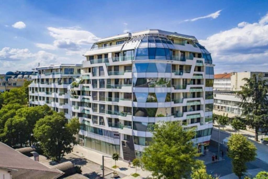 ein hohes Gebäude mit vielen Fenstern in der Unterkunft HOT Main Square Newly Built Modern Apartment in Burgas City