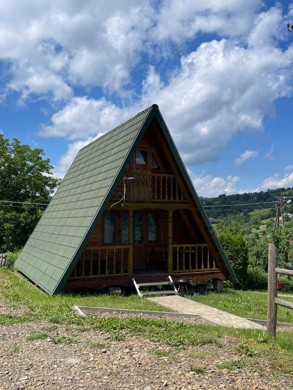 a large wooden cabin with a gambrel roof at Domek nad Solinką l in Wołkowyja