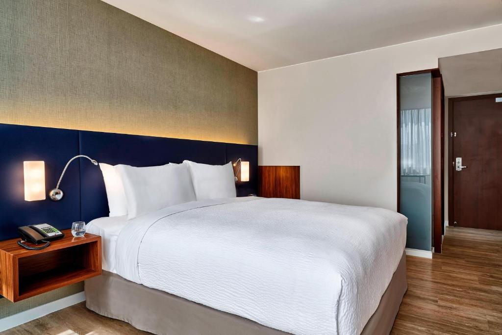 リオデジャネイロにあるコートヤード バイ マリオット リオデジャネイロ バーハ ダ チジュカの大きなベッドと電話が備わるホテルルームです。