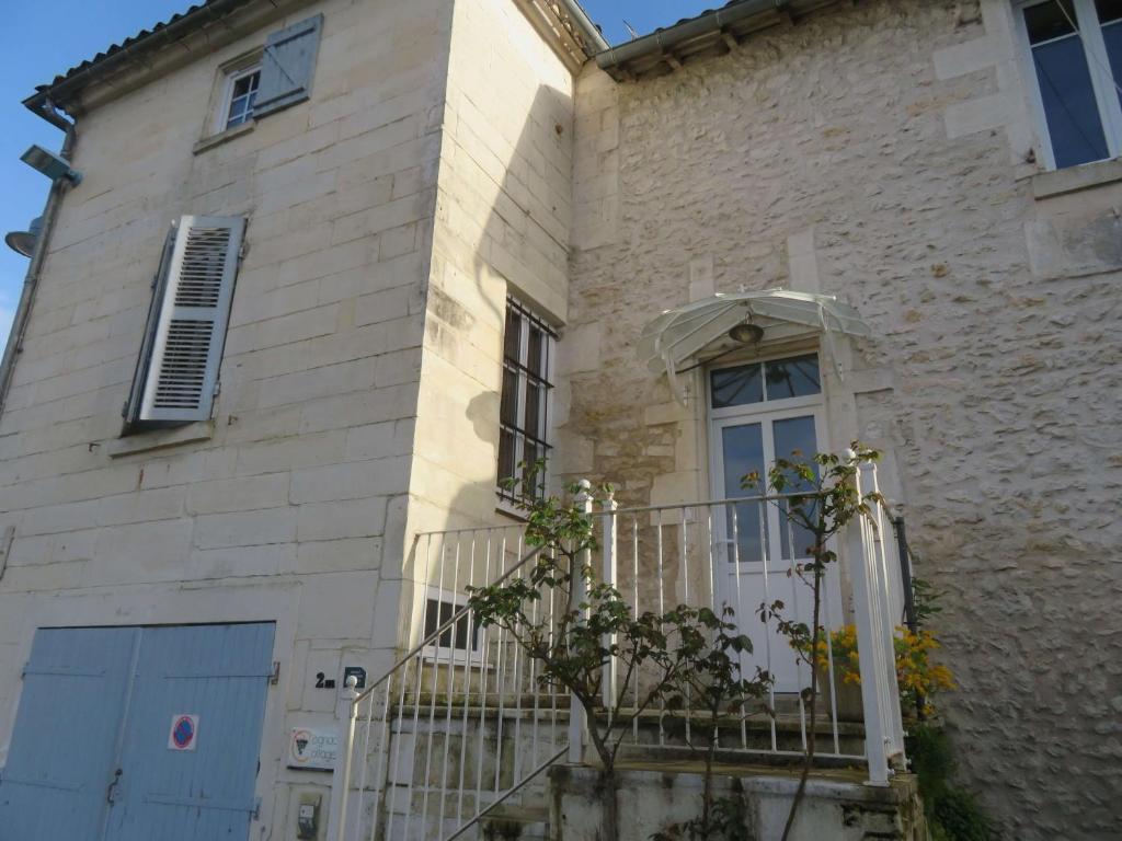 una casa con cancello e balcone di La Maison de Riviere a Bourg-Charente