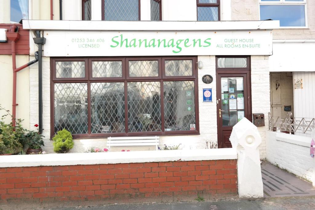 ein Geschäft mit einer Bank vor einem Gebäude in der Unterkunft Shananagens Guesthouse in Blackpool
