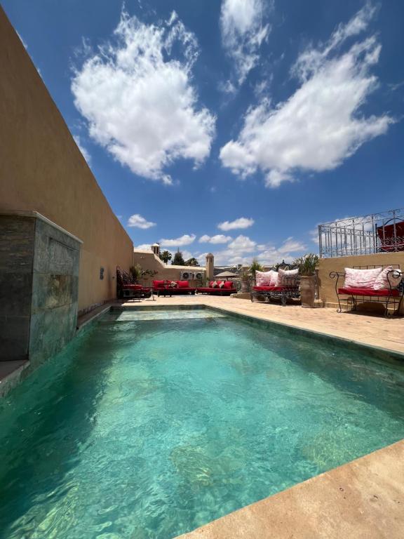 una piscina con acqua blu in un cortile di Riad Jnan El Cadi a Marrakech
