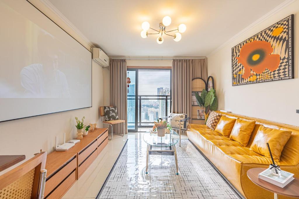 una sala de estar con un sofá y una mesa en SkyInn-Europark, en Shenzhen