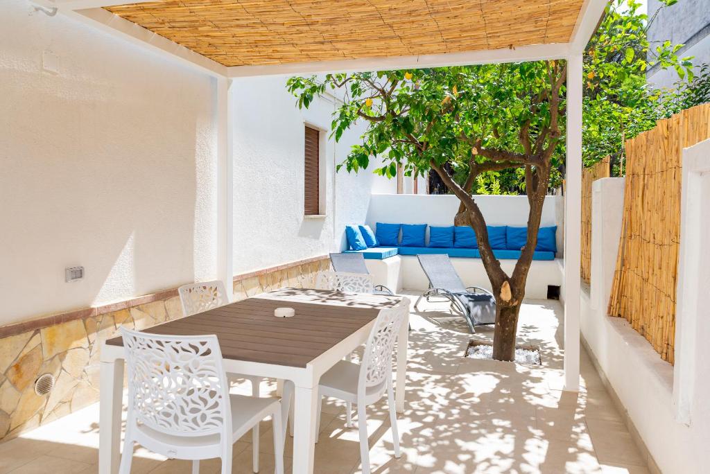 un patio con tavolo, sedie e un albero di Casa Vacanze Elvè a Paestum