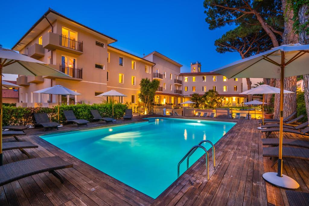 una piscina in un hotel con sedie e ombrelloni di Marina Garden Hotel a Marciana Marina