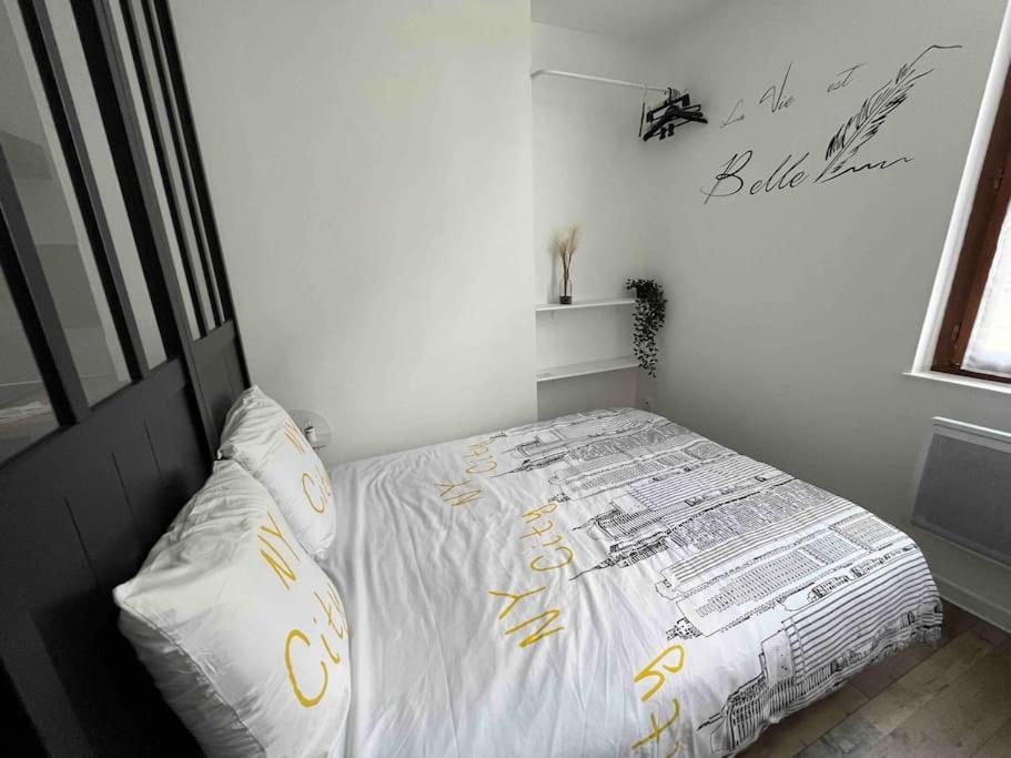 - une chambre avec un lit orné d'écritures jaunes dans l'établissement Grand studio 1er étage au calme centre ville proximité Cathédrale, à Orléans