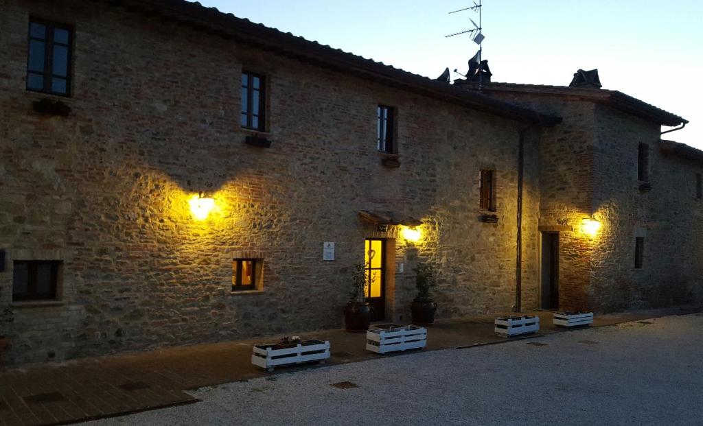 a large brick building with lights on it at Dimora Fra' Giovanni B&B Relais in Magione
