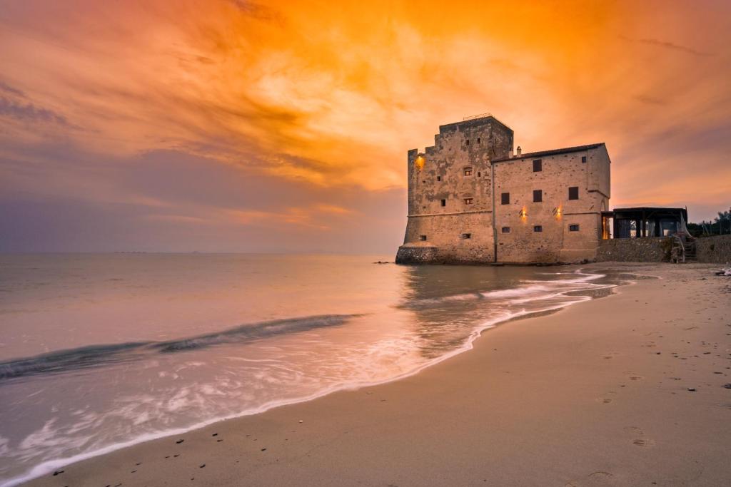 an old castle on the beach at sunset at Torre Mozza - Dimora d' Epoca in Follonica