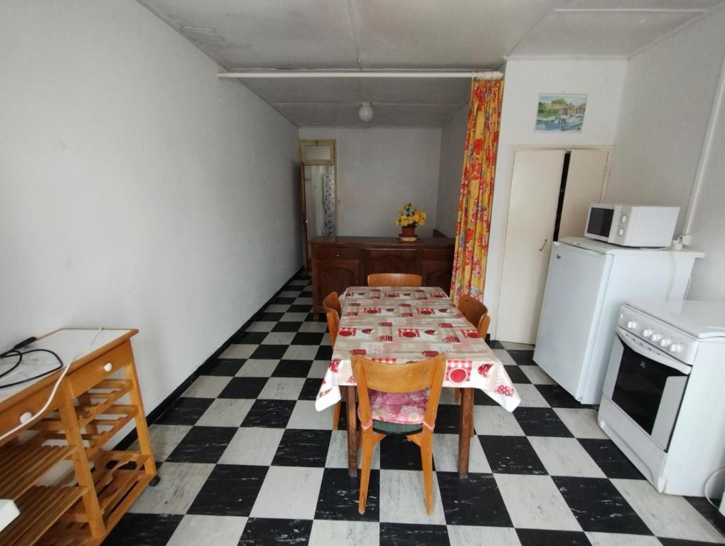 une cuisine avec une table et des chaises dans une pièce dans l'établissement La plaisance, à Notre-Dame-de-Monts