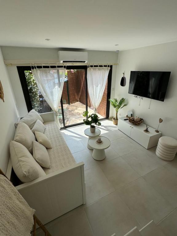 a living room with a white couch and a tv at Chez Timmaflo in Fréjus