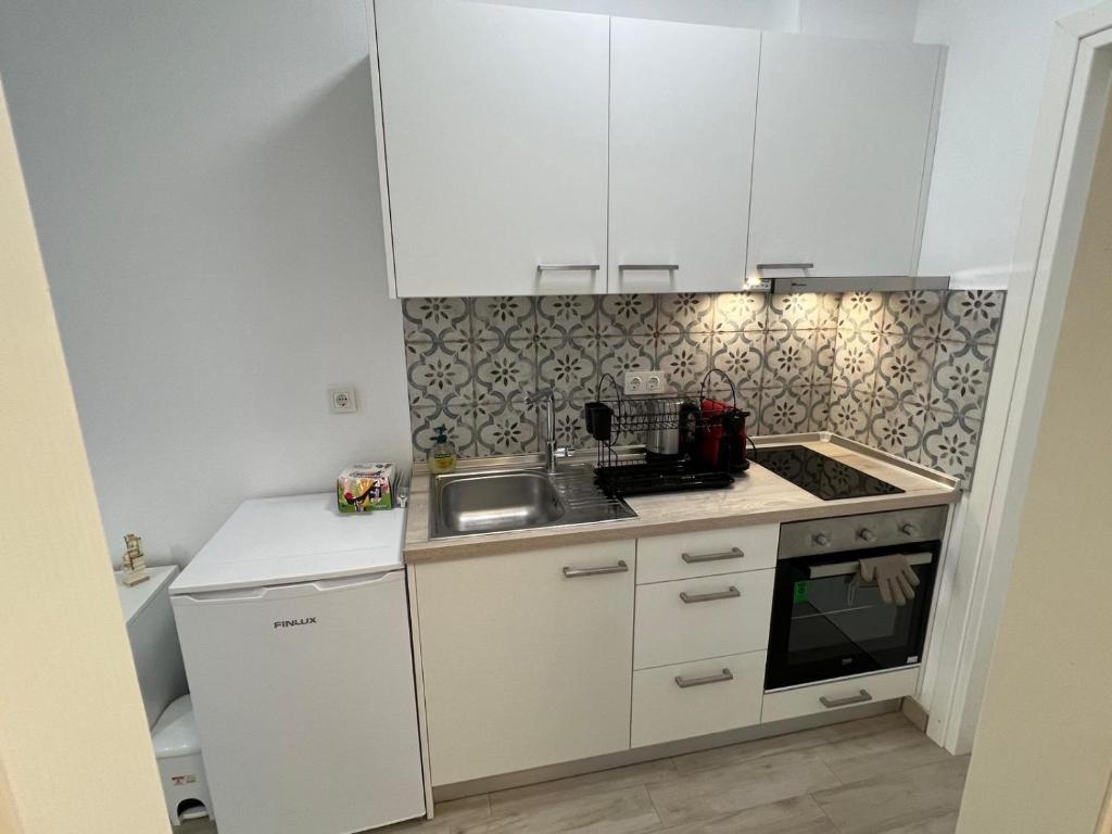 a small kitchen with white cabinets and a sink at Perla 2 Paralia Ofriniou in Ofrínion