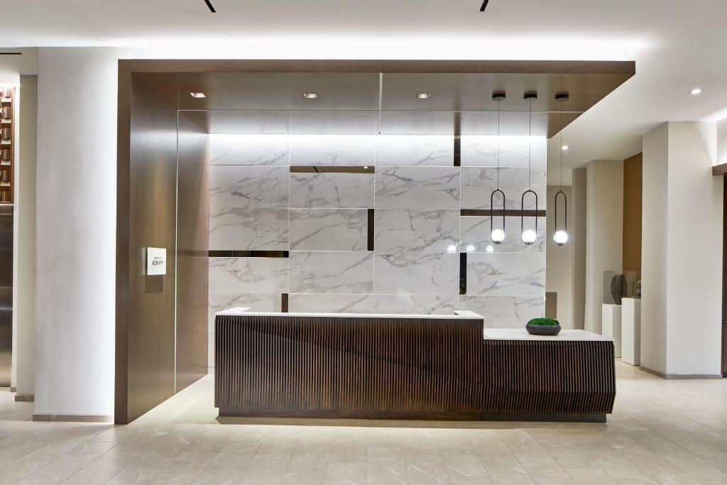 uma cozinha com paredes de mármore branco e um balcão em AC Hotel by Marriott Sacramento em Sacramento
