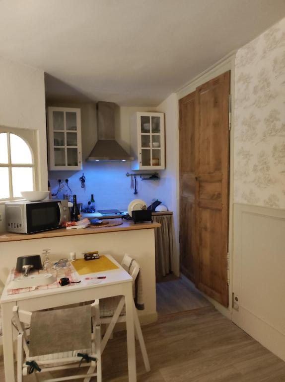 une cuisine avec une table et une cuisine aux murs bleus dans l'établissement La terrasse du champ clos, à Dinan