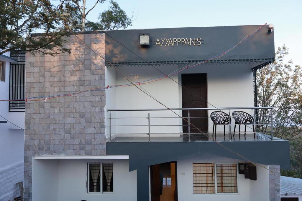two chairs on the balcony of a house at Marvel Homestay in Yercaud
