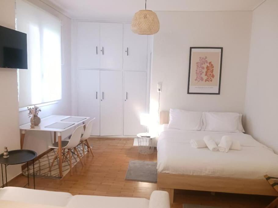 a white bedroom with a bed and a desk at Beautiful Downtown Studio! in Ioannina