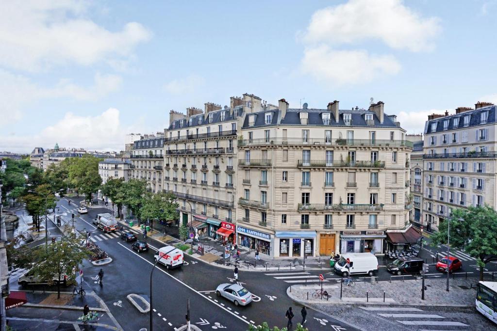 une rue urbaine animée avec des voitures et des bâtiments dans l'établissement Appartement familial avec vue - République, à Paris