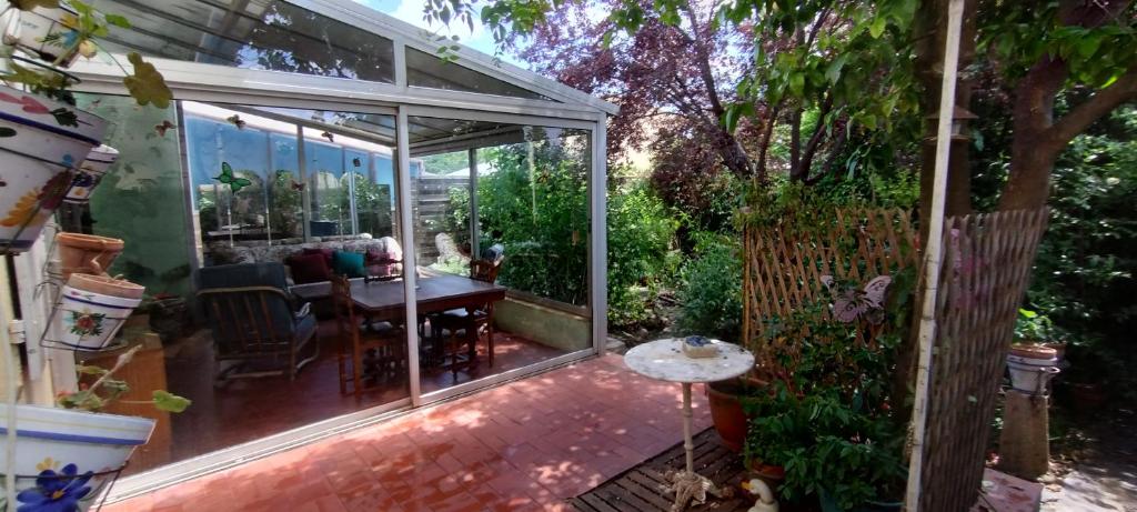 a glass extension of a house with a table in a garden at Maison de ville avec jardin in Thuir