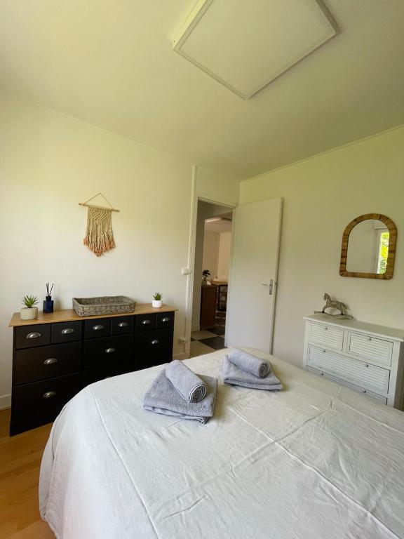 une chambre avec un lit blanc avec des serviettes dessus dans l'établissement Charmante petite maison, à Varengeville-sur-Mer