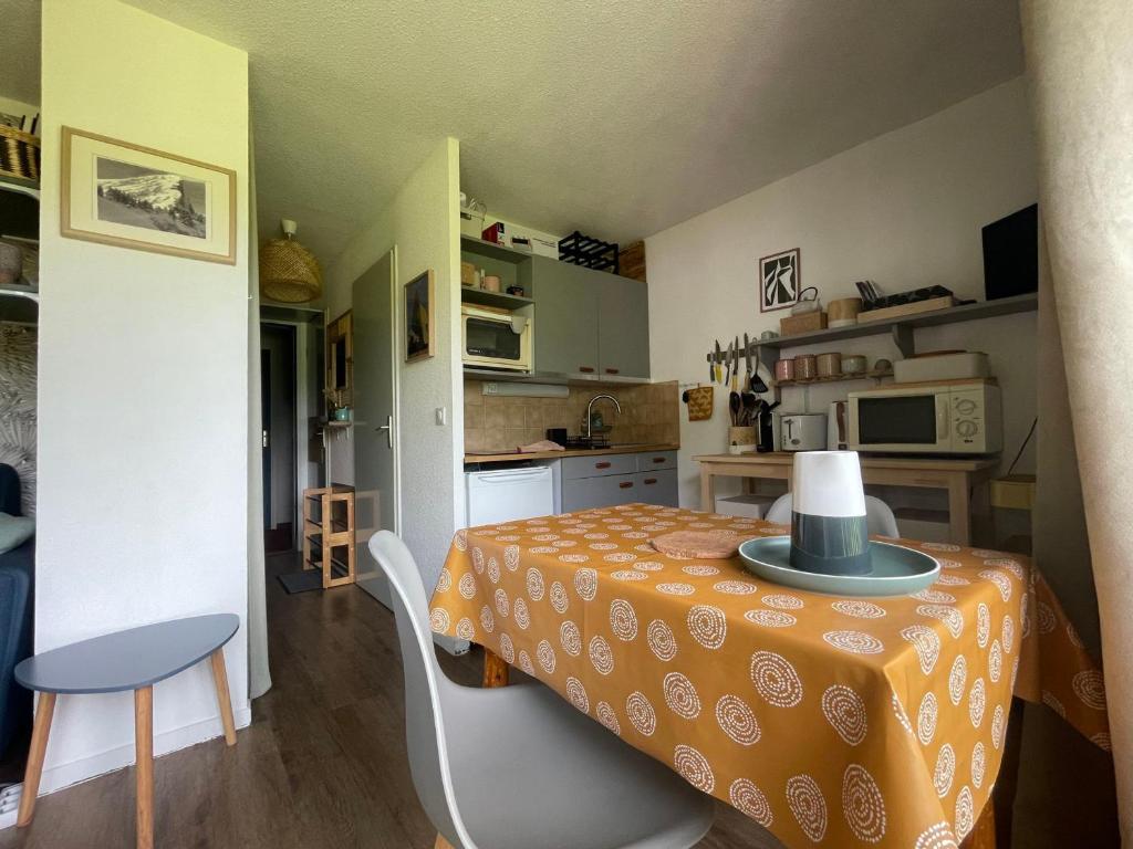 - une petite cuisine avec une table et un chapeau dans l'établissement Charmant Studio Cabine entre Abondance et La Chapelle d'Abondance, Parking et Balcon Inclus - FR-1-692-98, à Abondance