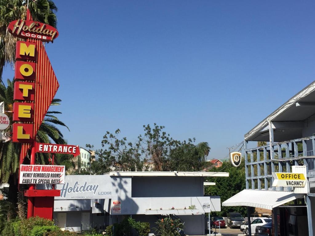 una calle de la ciudad con un hotel y un cartel en Holiday Lodge, en Los Ángeles