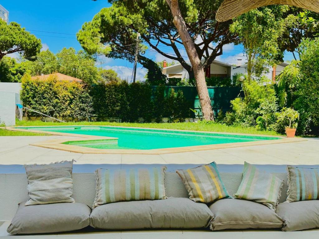 un divano seduto di fronte alla piscina di Villa Nola Cascais a Cascais