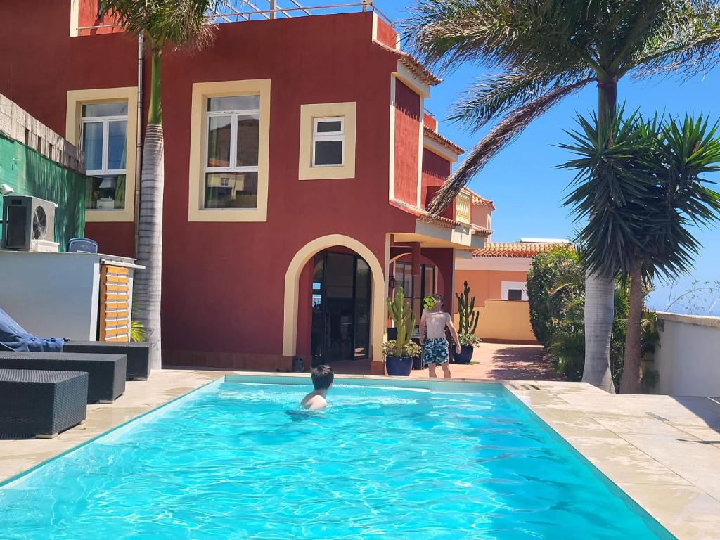 a boy in a swimming pool in front of a house at Casa Viera in Buzanada
