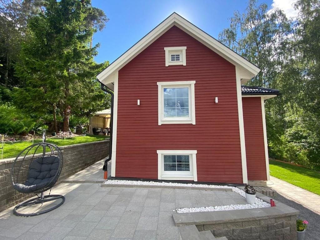 una casa roja con una silla delante en Charming apartment in a red house in Stockholm en Estocolmo