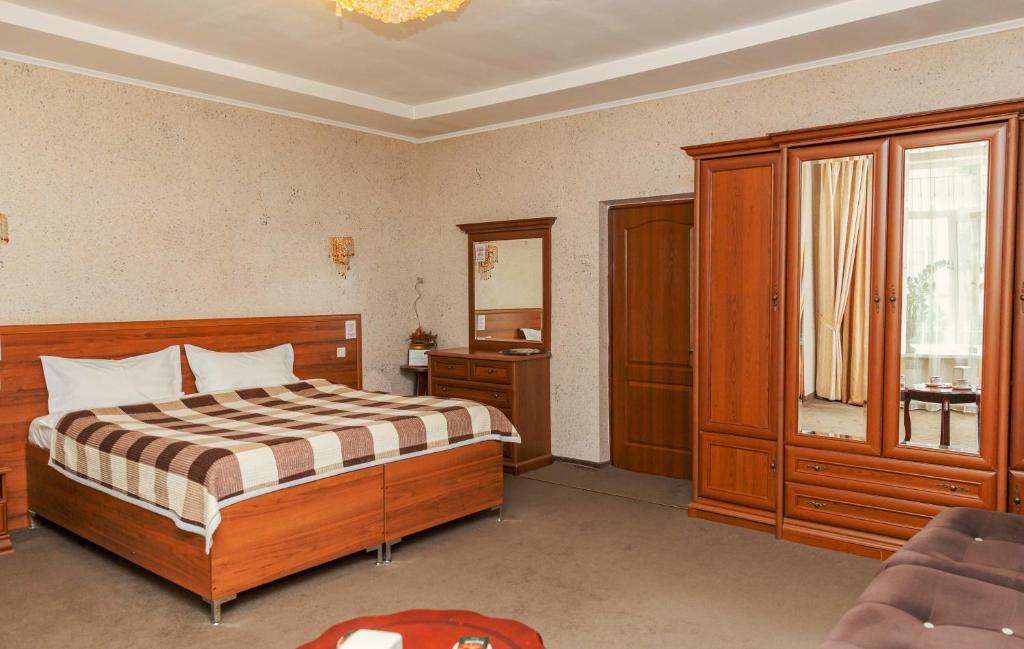 阿拉木圖的住宿－阿約爾酒店，一间卧室设有一张大床和一个窗户。