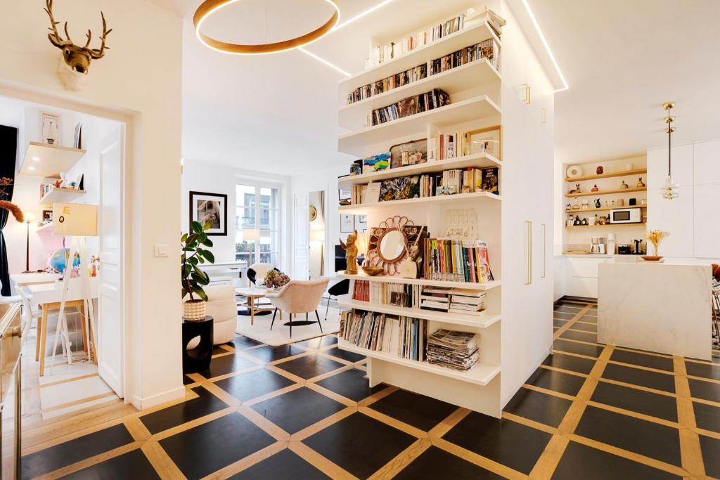 - un salon avec une grande étagère dans l'établissement Appartement spacieux et élégant - Grds Boulevards, à Paris