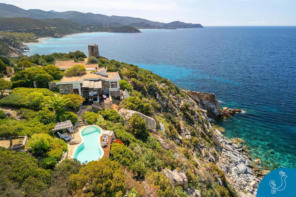 una vista aerea di una casa su una scogliera vicino all'oceano di Aqua - Maison de charme with sea view and pool a Quartu SantʼElena