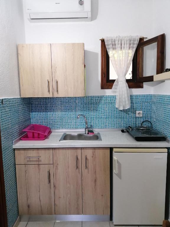 a kitchen counter with a sink and a window at Avra Ηouse in Kriopigi