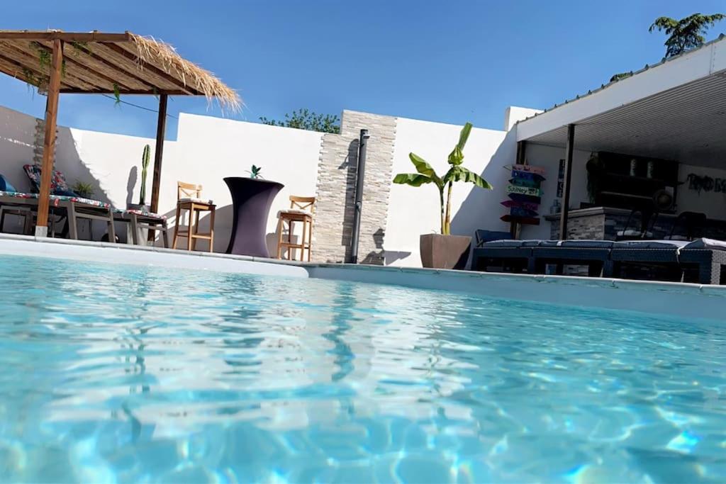 une piscine avec de l'eau bleue devant un immeuble dans l'établissement Charmant studio au calme avec piscine, à Lespignan