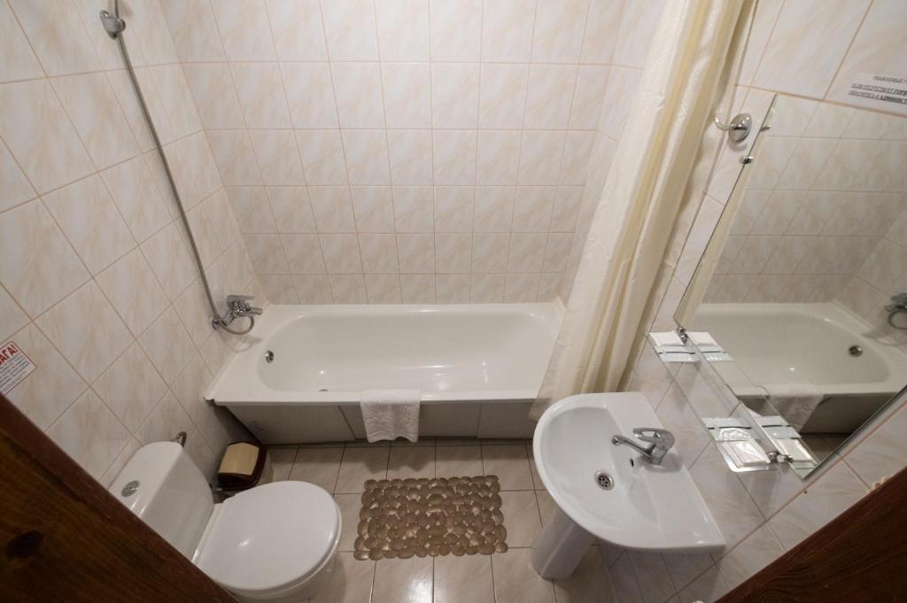 La salle de bains est pourvue d'une baignoire, de toilettes et d'un lavabo. dans l'établissement Hotel LaMa 2, à Kiev