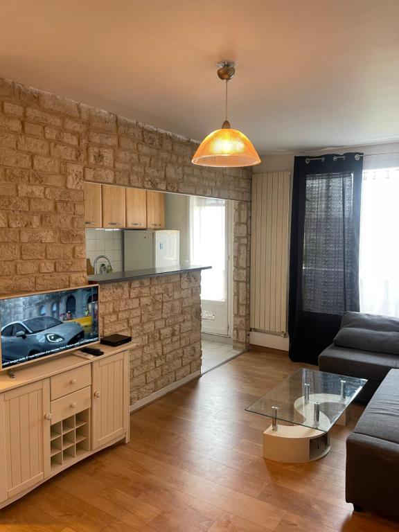 a living room with a couch and a tv at Apartment in Épinay-sur-Seine