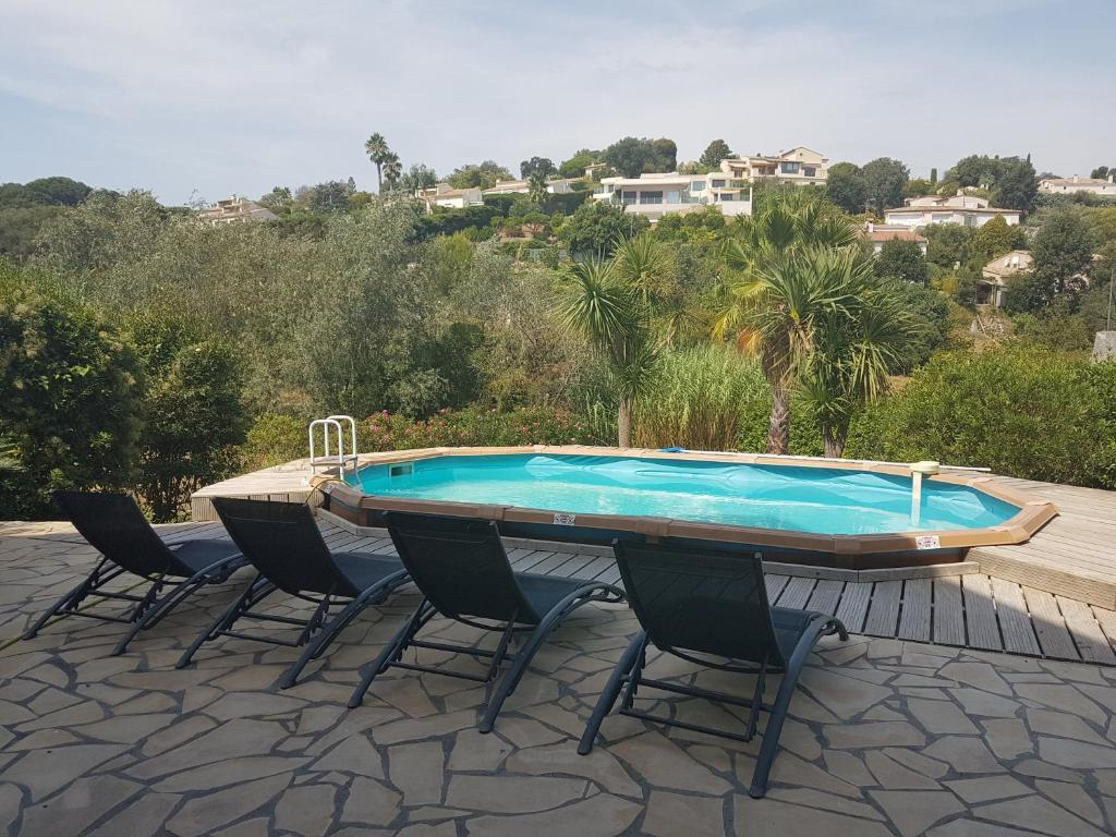 une piscine sur une terrasse avec des chaises et une table dans l'établissement Villa Constance 2 - Spacieux Duplex avec piscine privative, à Antibes