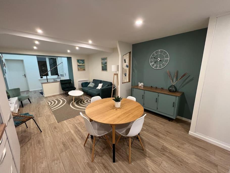 una sala de estar con una mesa y un sofá en Peace & Loire, en Cosne-Cours-sur-Loire