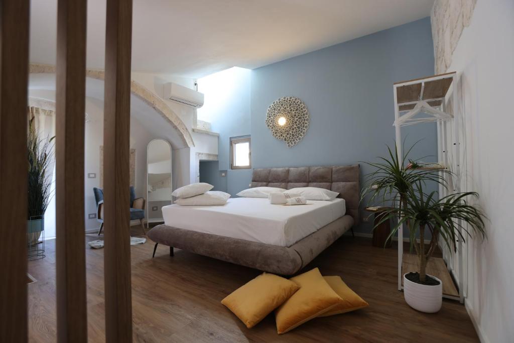 ein Schlafzimmer mit einem Bett und einer blauen Wand in der Unterkunft Dama Your Luxury Stay in Castellana Grotte